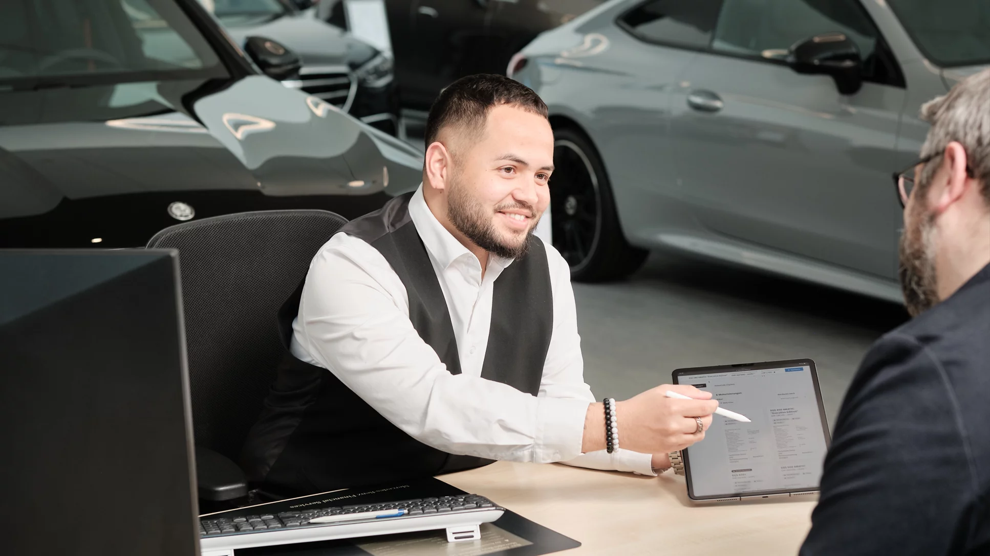 Automobil-Verkaufsberater:in mit eidg. Fachausweis bei der Arbeit.