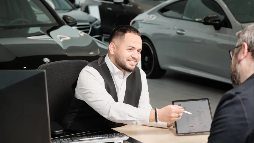 Automobil-Verkaufsberater:in mit eidg. Fachausweis bei der Arbeit.