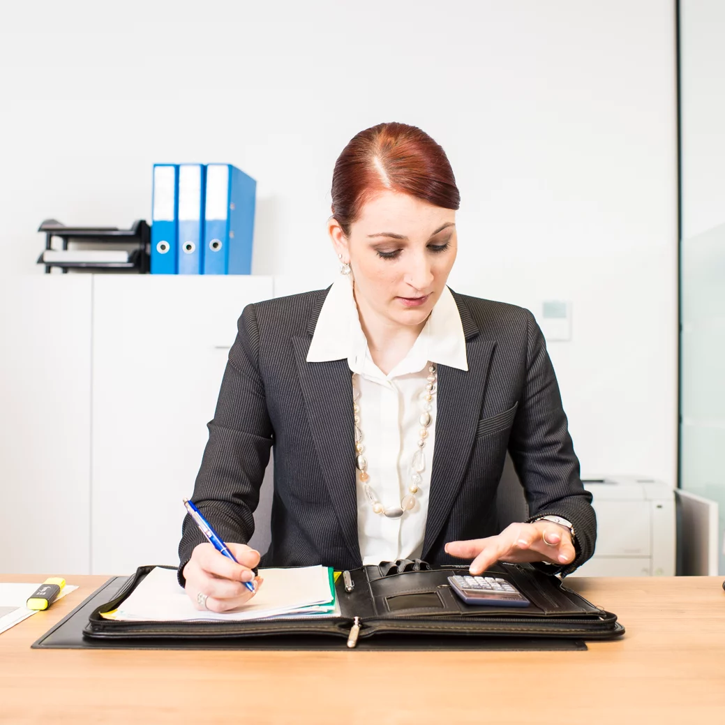 Conseiller/ère de vente d’automobiles avec brevet fédéral lors de la préparation des documents contractuels.