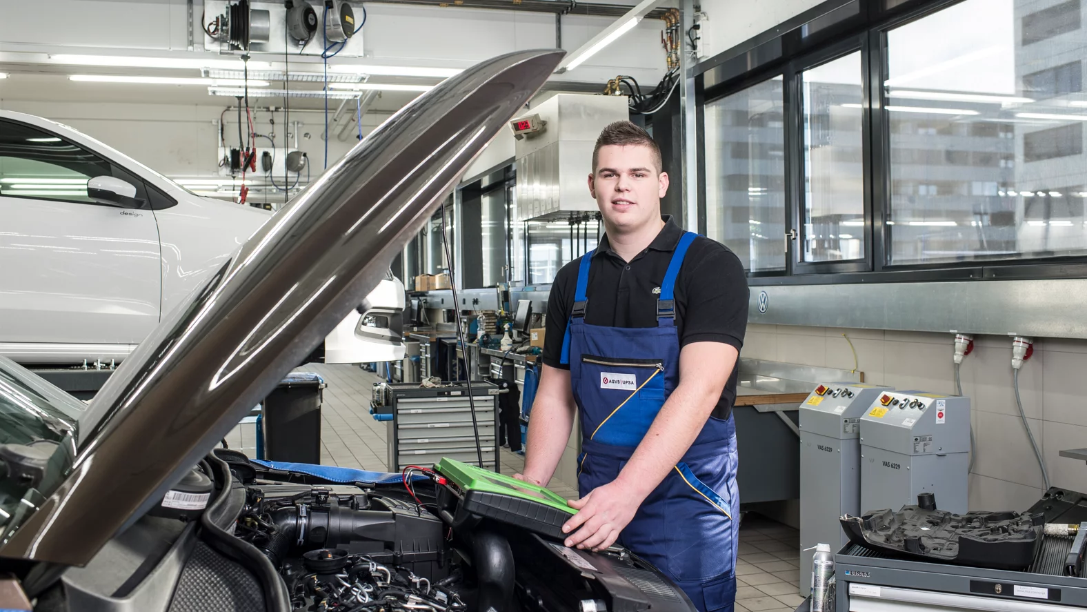 Le/La diagnosticien/ne d’automobiles avec brevet fédéral travaille sur le véhicule.