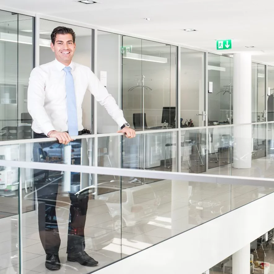 Il/La diplomato/a in economia aziendale nel ramo dell’automobile si trova nello showroom.