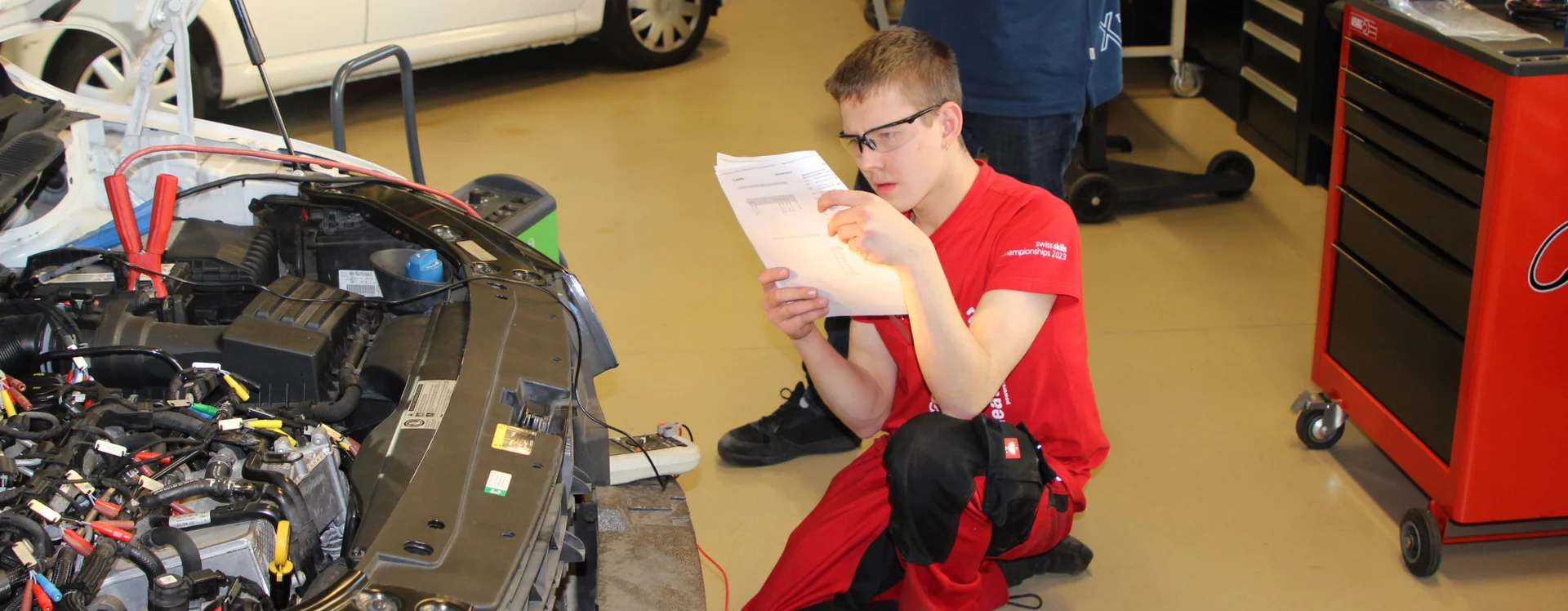 Nevio Bernet beim Studieren eines Plans vor dem Fahrzeug.